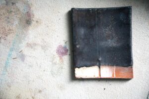 decorative image of a clay test tile displayed on a paint splattered canvas